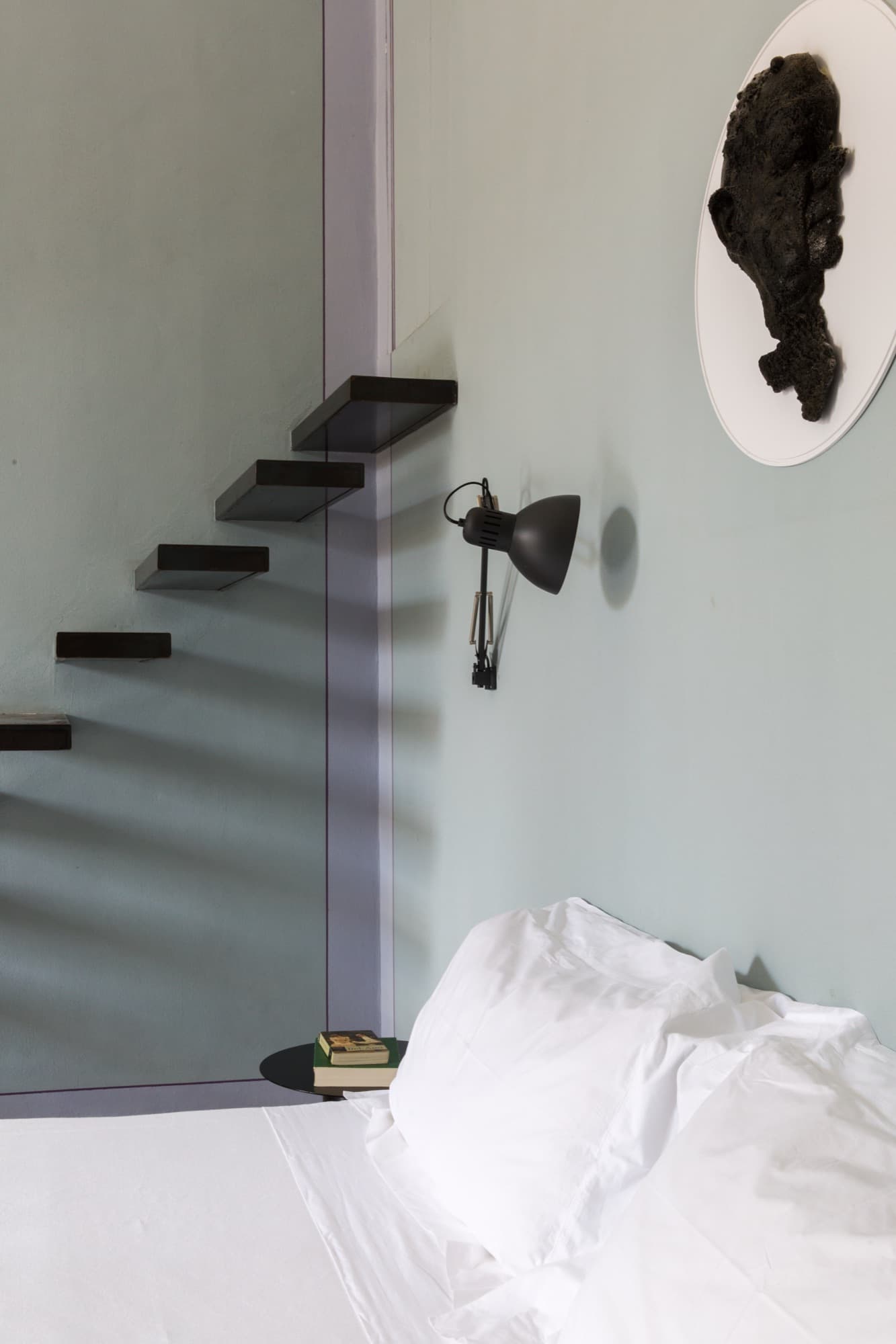 Bedroom beneath a floating stone stair
